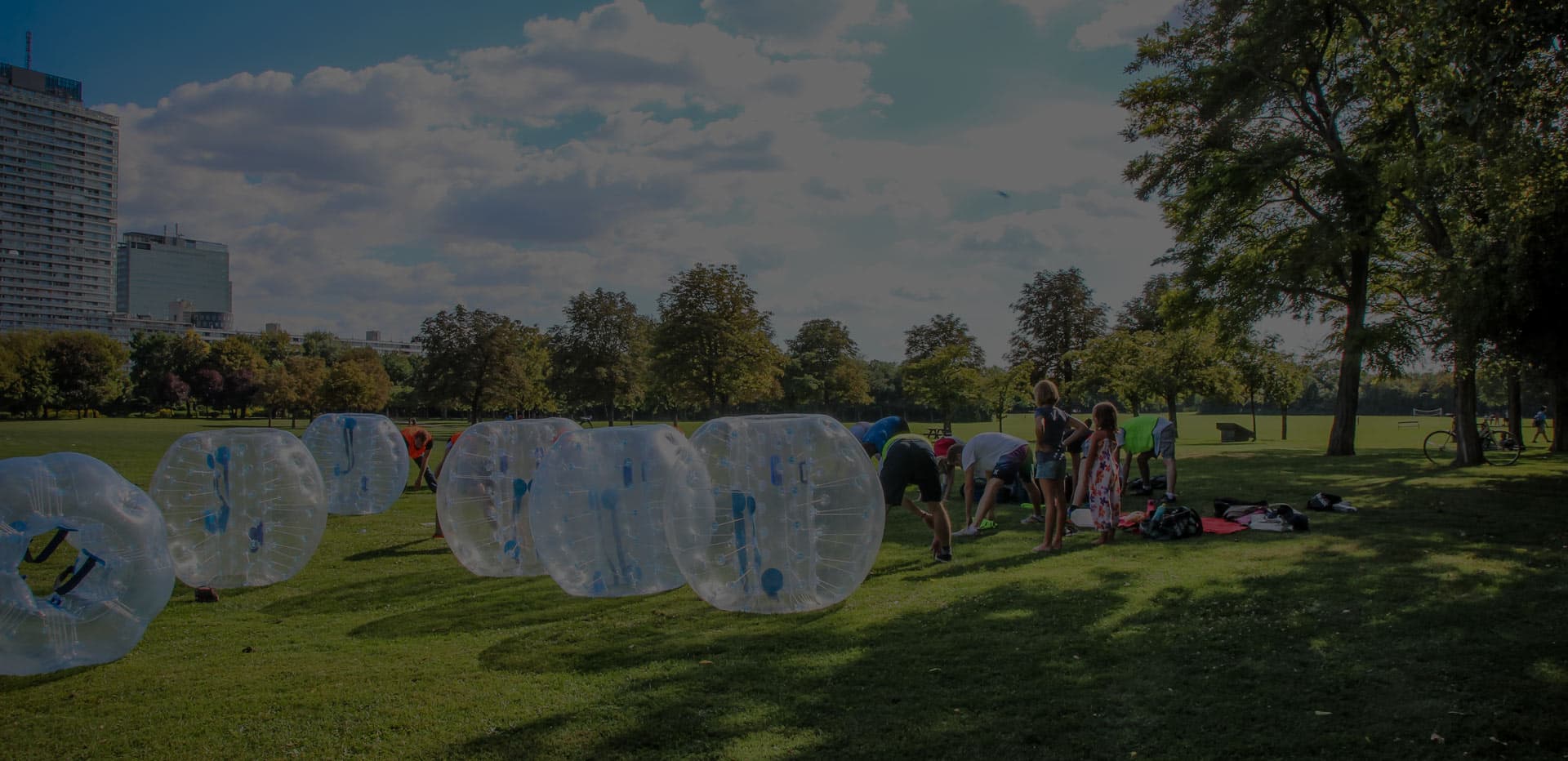 Eine Reihe transparenter Bubble Soccer Bälle auf einer Wiese im Park, bereit zum Spiel